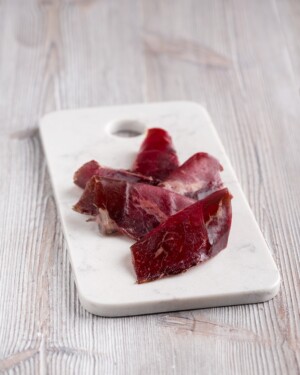 lonchas de Cecina de León con I.G.P sobre tabla de mármol blanco