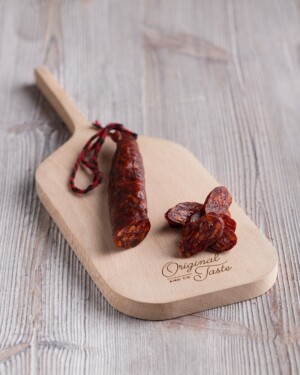 chorizo dulce en pieza, mostrando el corte sobre tabla de madera