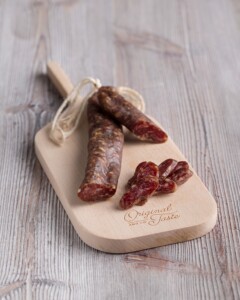 Fuet catalan tradicional.Pieza estrecha servida sobre tabla de madera, se muestra el corte.