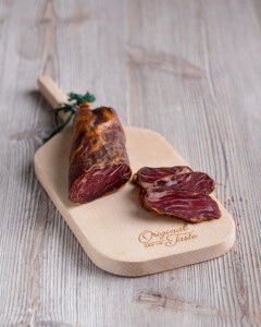 Lomito Ibérico de Bellota adobado a mano se muestra corte sobre tabla de madera