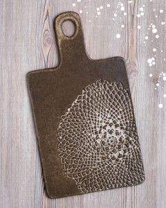Tabla de ceramica oscura con grabado artesanal. Mango y agujero para colgar