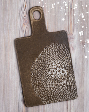 Tabla de ceramica oscura con grabado artesanal. Mango y agujero para colgar